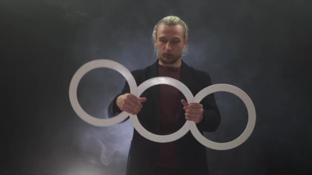 Homme portant un noir manipulant avec des anneaux blancs. concentration et attention — Video