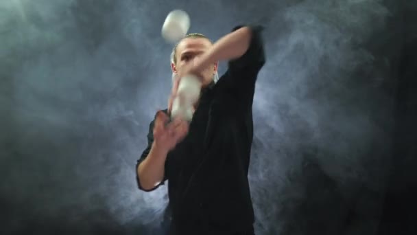Мужчина в черном жонглирует белыми шарами. Управление, контроль и успех — стоковое видео
