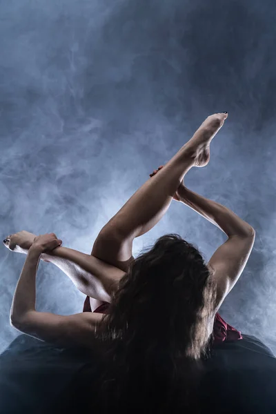 Concepto de arte, creatividad y pasión. Mujer flexible sobre fondo negro — Foto de Stock