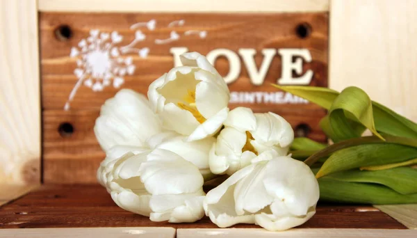 Houten paneel bord met "love is in the air" bericht op houten achtergrond Stockfoto