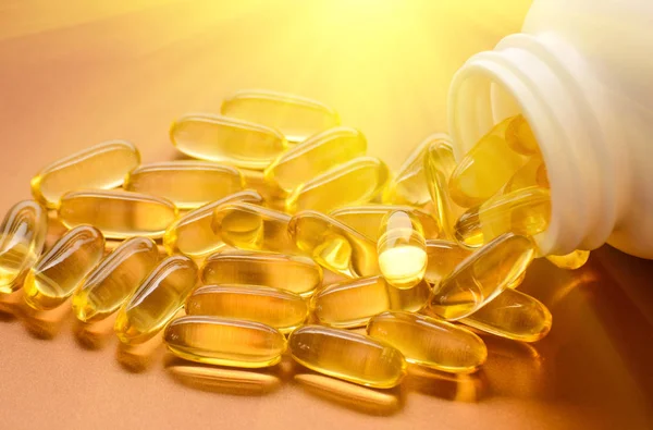 Capsules d'huile de poisson avec oméga 3 et vitamine D sur une texture brillante, concept d'alimentation saine — Photo