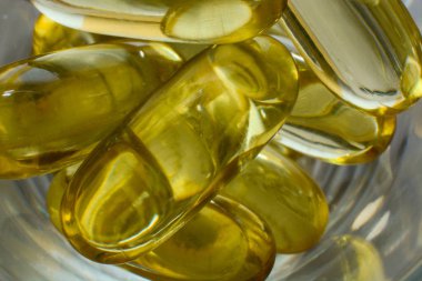 Balık yağı omega 3 ile jelatin softgels ve ahşap doku güneş ışınları, sağlıklı beslenme kavramı ile D vitamini