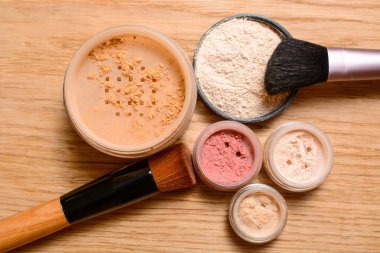Dekoratif kozmetik kümesi. Toz, ışıltı, göz farı, allık ve fırçalar ahşap arka plan, güzellik ve makyaj kavramı