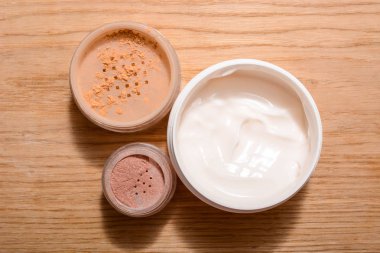 Dekoratif kümesi ve bakım kozmetik. Ahşap arka plan, güzellik ve makyaj konsept üzerine krema, pudra ve pırıltılı allık