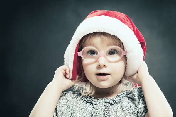 Christmas barn. Söta lilla flicka k i Santa hatt. — Stockfoto
