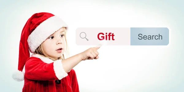 Το παιδί με το καπέλο Santa αναζητήστε ένα δώρο δώρα ing. Χριστούγεννα παιδί — Φωτογραφία Αρχείου