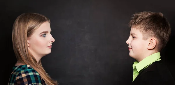 Giovane ragazzo e ragazza guardando l'un l'altro su sfondo lavagna . — Foto Stock