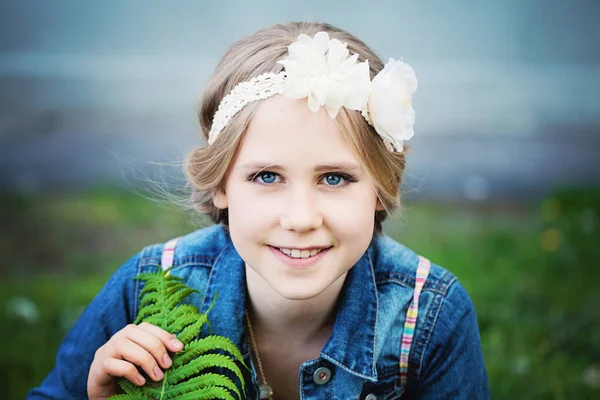 Ung flicka med grönt blad utomhus. Våren — Stockfoto