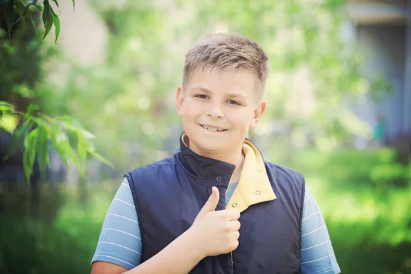 Giovane ragazzo mostrando pollice fino gesti all'aperto — Foto Stock