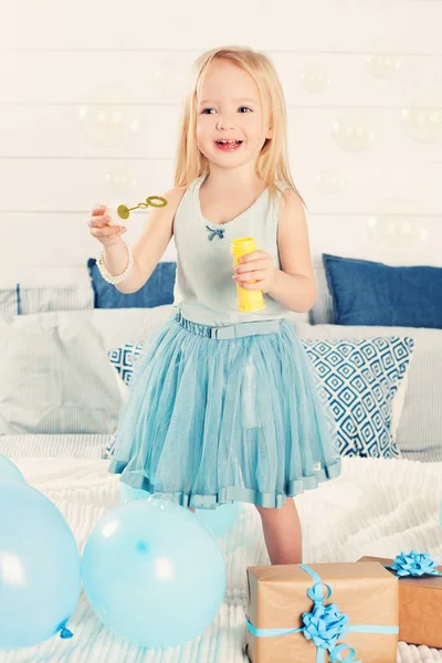 シャボン玉を吹く少女を笑っています。かわいい子自宅 — ストック写真