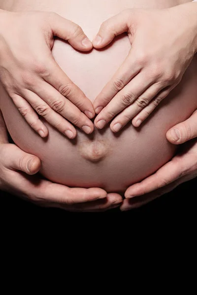 Die Hände der Eltern machen ein Herz auf dem Bauch der Schwangeren — Stockfoto
