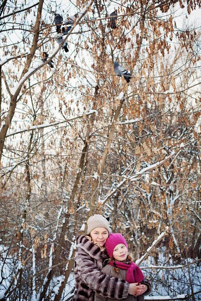 幸福的母亲和女儿拥抱在冬季公园户外活动。爱你，你 — 图库照片