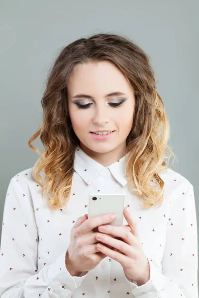 Een lachende vrouw kijken naar haar mobiele telefoon — Stockfoto