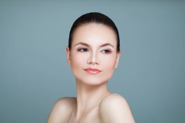 Sevimli yüz ve mavi arka plan üzerine açık cilt sağlıklı kadınla. 