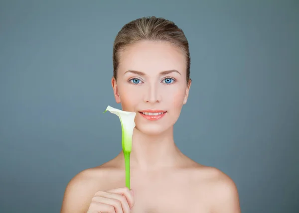 Natürliche Schönheit. gesunde Frau mit Lilienblüte lächelnd — Stockfoto