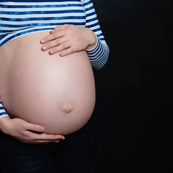 Barriga da mãe grávida em fundo preto com Copyspace — Fotografia de Stock