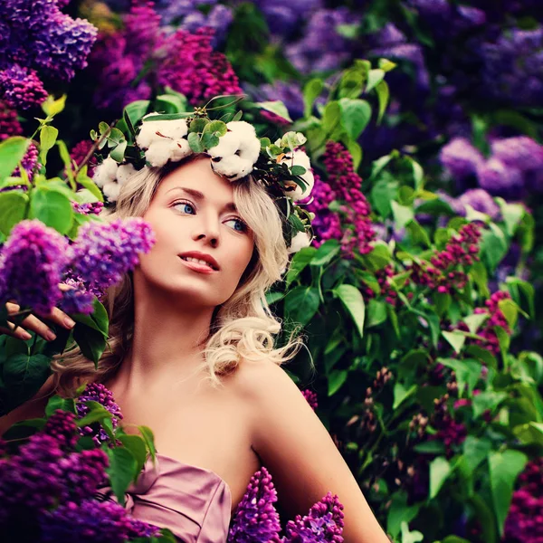 Молода білявка з квітами в саду навесні — стокове фото