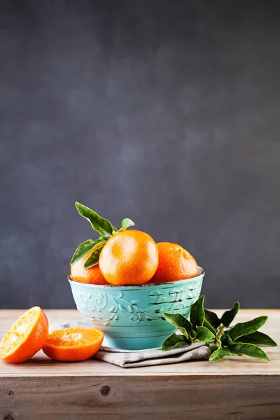 Mandarin gyümölcs, zöld levelek, fából készült táblán. Egészséges táplálkozás — Stock Fotó