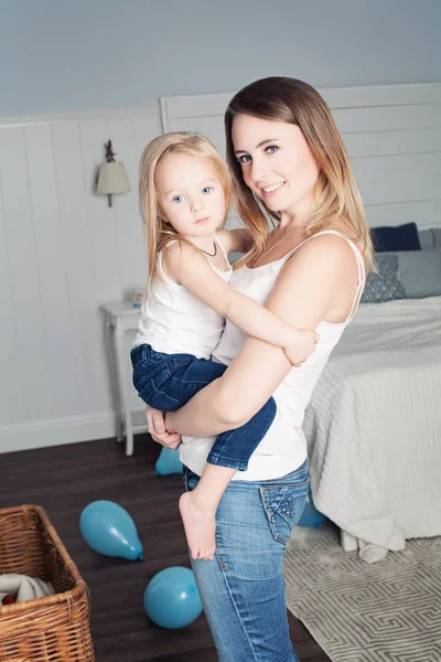 Mamá abraza a su hija. Madre e hija sonrientes en casa — Foto de Stock