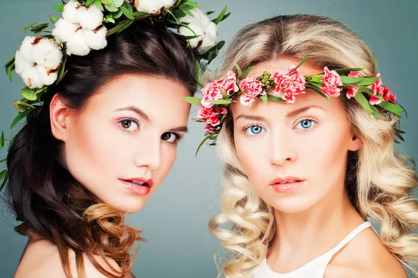 Vackra kvinnor med permanentat frisyr, smink och blommor — Stockfoto