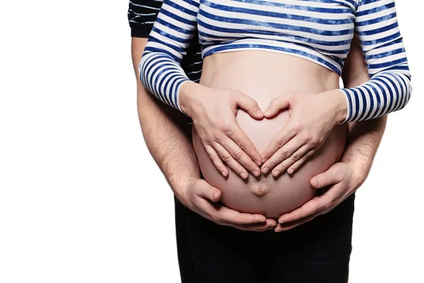 Casal feliz à espera de um bebé. Pais mãos fazendo um coração no — Fotografia de Stock