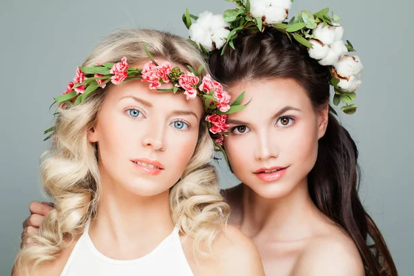 Vackra kvinnor med permanentat frisyr, smink och blommor. Unga skönhet — Stockfoto