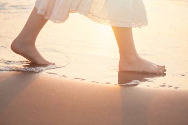 Girl Barefoot are Walking on the Beach in Water. Vacation in Sum clipart