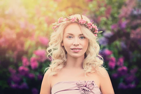 Mujer rubia joven con corona de flores y luz solar al aire libre —  Fotos de Stock