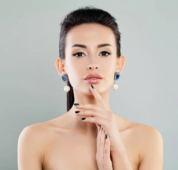 Hermosa mujer modelo con maquillaje, manicura y pendientes —  Fotos de Stock