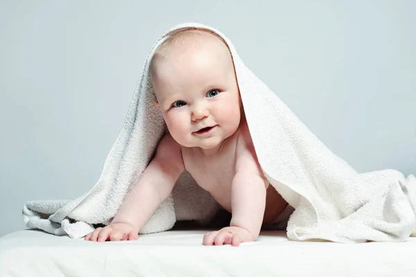 Glückliches Baby im weißen Handtuch auf Hintergrund, elterliches Pflegekonzept — Stockfoto