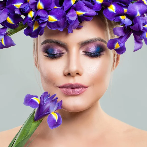 Schöne Frau mit Make-up und Irisblumen auf dem Kopf. — Stockfoto