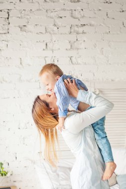 Anne ve küçük çocuk yastıklar oynarken