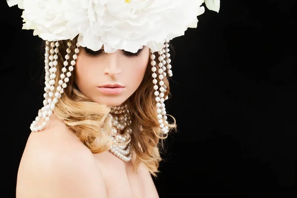Mooie vrouw met blond krullend kapsel, make-up en bloemen — Stockfoto