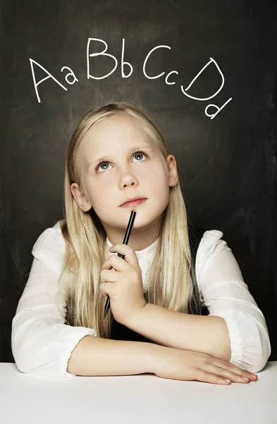 Menina bonito aprendendo linguagem no fundo do quadro negro — Fotografia de Stock