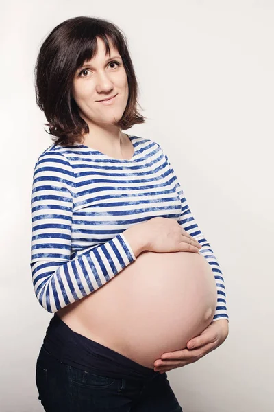 Schwangere in blauem Tuch auf grauem Hintergrund — Stockfoto