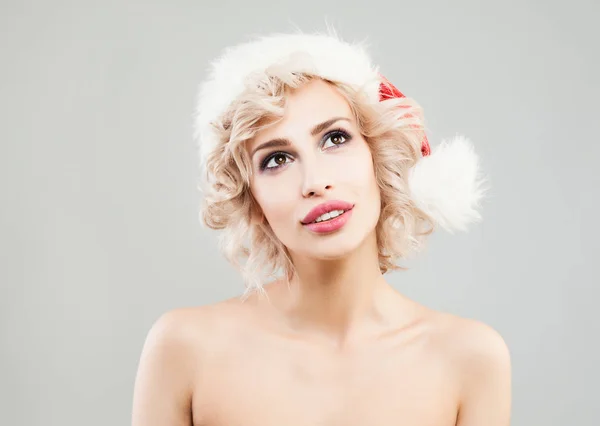 Mujer rubia de Navidad mirando hacia arriba sobre fondo gris . —  Fotos de Stock