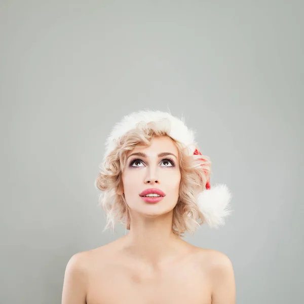 Roztomilý vánoční žena dívá nahoru na šedém pozadí. Hezké děvče — Stock fotografie
