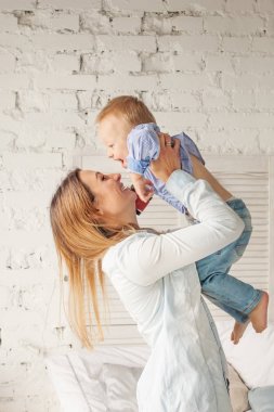 Gülümseyen anne ve oğlu evde eğleniyor. Mutlu kadın ve çocuk