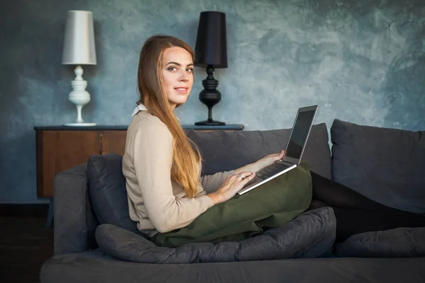 Leende kvinna som använder laptop hemma — Stockfoto