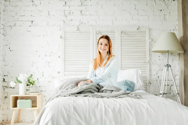 自宅のベッドの上で座ってパジャマでかわいい優しい女性. — ストック写真