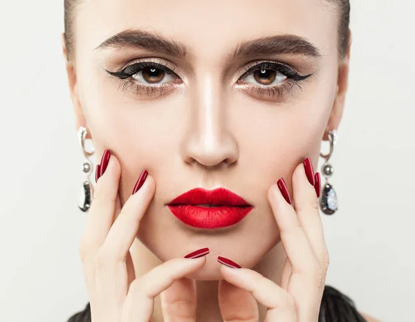 Perfecte vrouwelijke gezicht close-up. Meisje met rode kleurrijke Manicure — Stockfoto