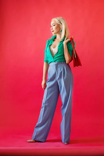 Elegante modello di moda donna bionda con borsetta su rosso — Foto Stock