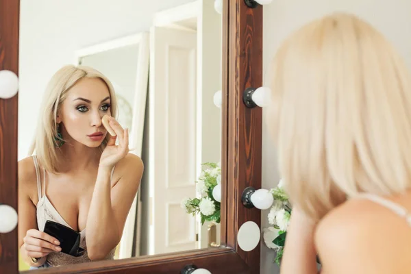 Mladá blond žena použití make-up. Krásná žena hledá — Stock fotografie