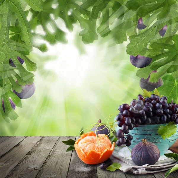 Мандарин, інжир, виноград плоди на абстрактні зелений Боке — стокове фото