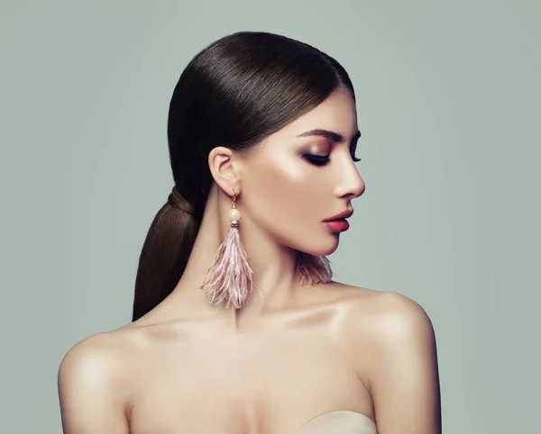Elegantní žena s culíkem účes a růžové náušnice — Stock fotografie