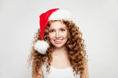 Mutlu Noeller Noel Baba şapkalı kadın beyaz arka planda gülümsüyor.. 