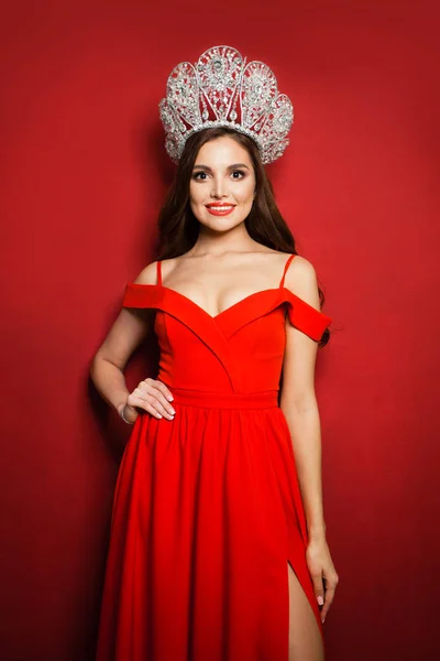 Nádherná žena módní model na sobě červené šaty a diamantová koruna — Stock fotografie