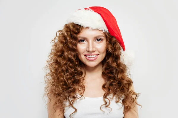 Glad ung kvinna i Santa hatt ler på vit bakgrund. — Stockfoto