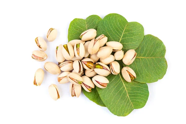 Tasty pistachio nuts with green leaves isolated on white — Stock Photo, Image