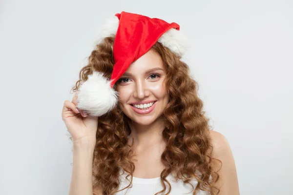 Šťastná mladá žena v santa klobouk s úsměvem na bílém pozadí. — Stock fotografie